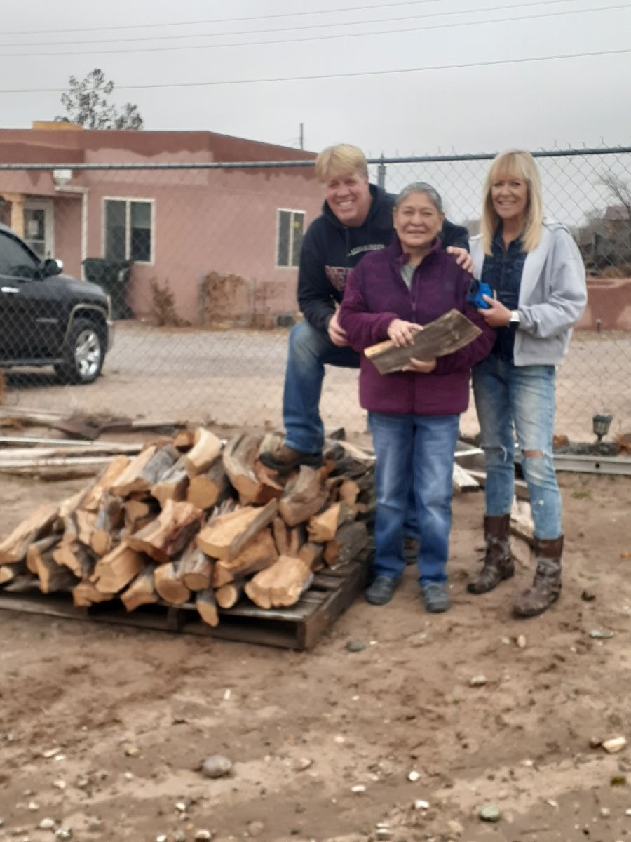Three women with a pallet of firewood